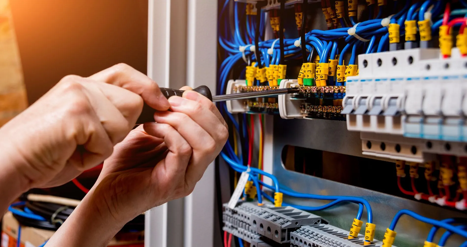 adobe 170179753 - The man is repairing the switchboard voltage with automatic switches.